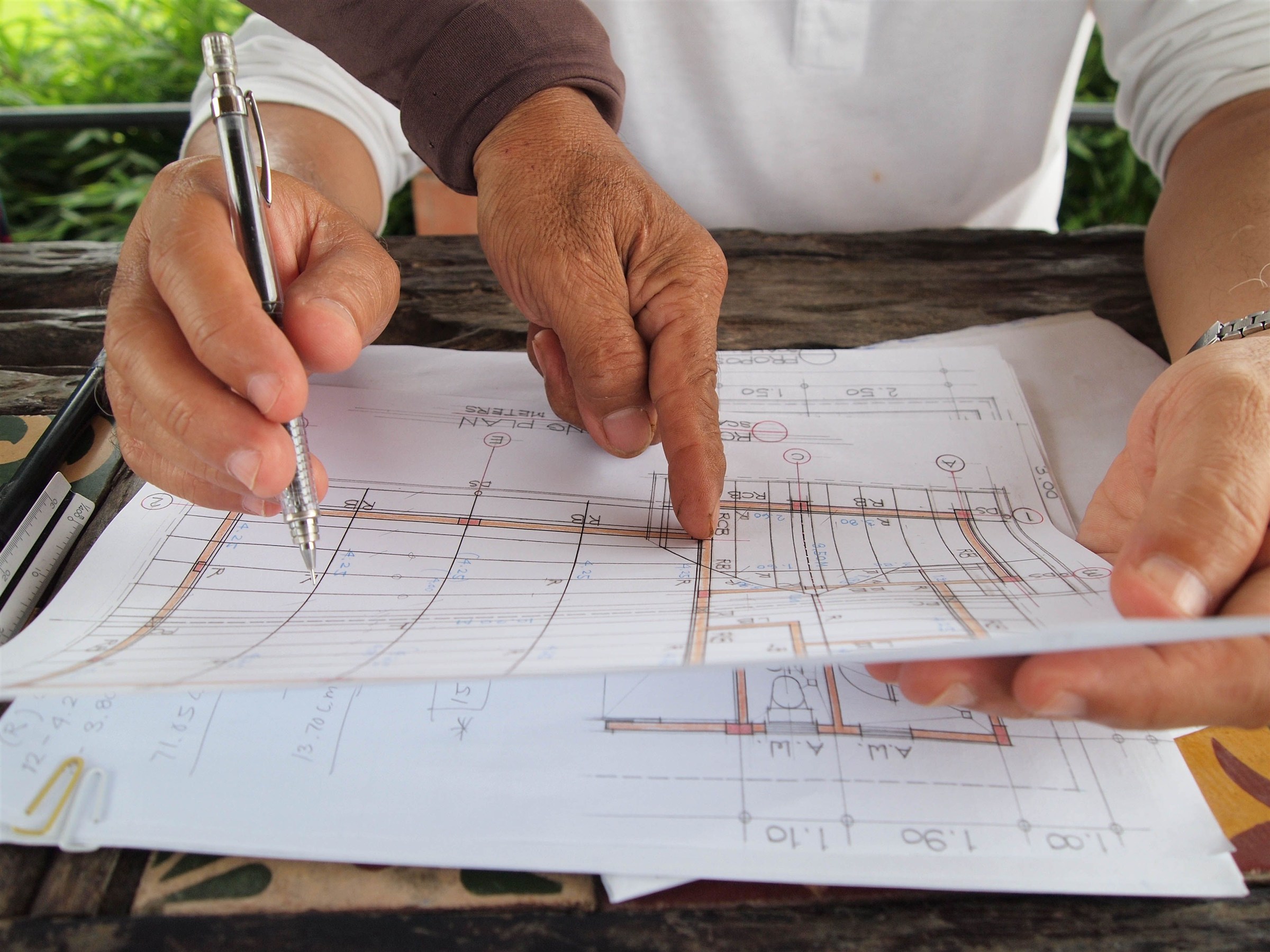 Two people reviewing detailed project drawings